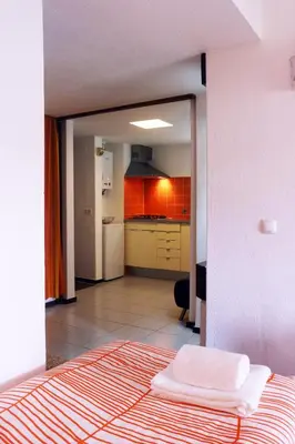 a view of a kitchen from a bedroom with a bed at Acoteias Beach Studio in Albufeira