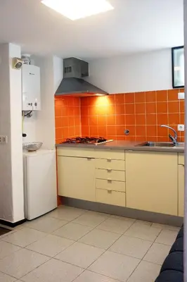 a kitchen with an orange tiled wall at Acoteias Beach Studio in Albufeira