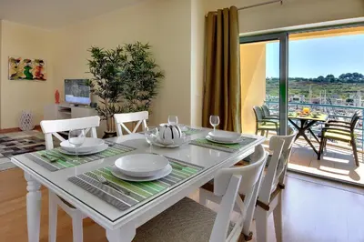 a dining room with a table and chairs and a balcony at Marina Coast Residence in Albufeira