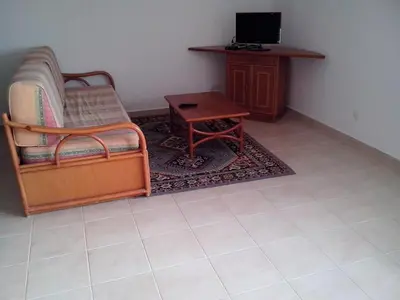 a living room with a chair and a table at Apartment with 1 Bedroom D in Albufeira