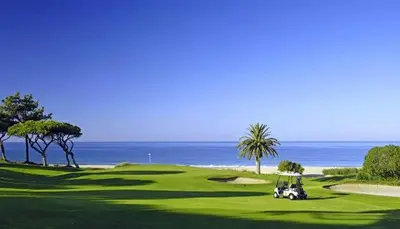 a golf cart on a green with the ocean in the background at Apartment with 1 Bedroom D in Albufeira