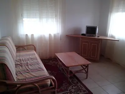 a living room with a chair and a table with a laptop at Apartment with 1 Bedroom L in Albufeira