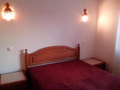 a bedroom with a wooden bed with two lights on the wall at Apartment with 2 Bedrooms B in Albufeira
