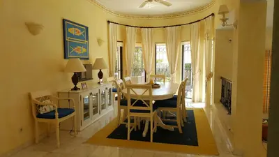 a dining room with a table and chairs at Dunas Douradas Beach Villa in Benfarras