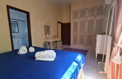 a bedroom with a blue bed with towels on it at Dunas Douradas Beach Villa in Benfarras