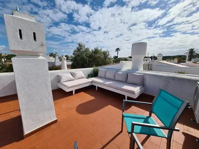 a patio with a couch and chairs on a roof at Aldeia do Golf - Vila I8 in Vilamoura