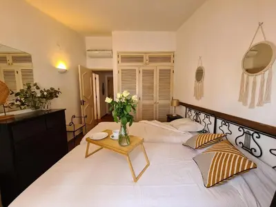 a bedroom with a bed with a vase of flowers on a table at Aldeia do Golf - Vila I8 in Vilamoura