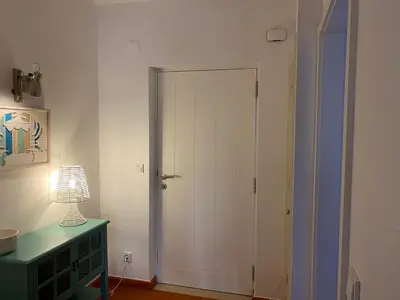 a white door in a room with a lamp at Quinta do lago & golf in Quinta do Lago