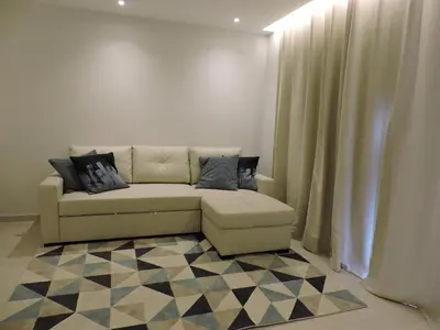 a living room with a couch and a checkered floor at Sao Rafael - Apartamento Studio in Albufeira
