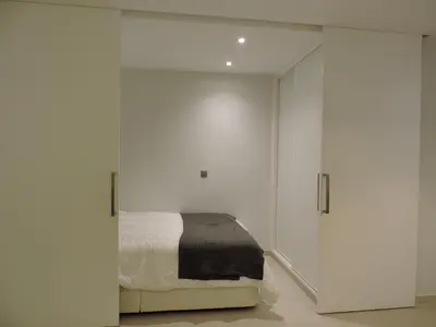 a bedroom with white cabinets and a bed at Sao Rafael - Apartamento Studio in Albufeira