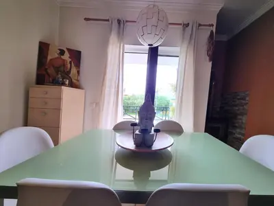 a green dining room table with chairs and a vase on it at T1 Falesia in Albufeira
