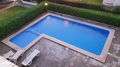 an overhead view of a swimming pool with two lawn chairs at Tulipa Férias (29506) in Vilamoura