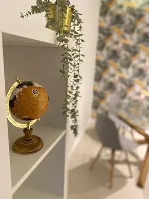 a vase with a plant on a stand next to a chair at Garden Hill Apartment in Albufeira