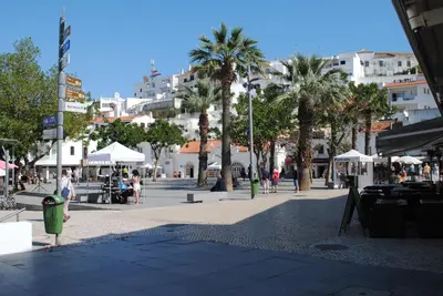 a city street with palm trees and buildings at Garden Hill Apartment in Albufeira