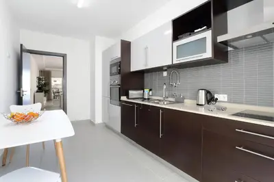 a kitchen with brown cabinets and a white counter top at Original 3 Bedroom Downtown in Albufeira