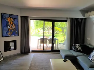 a living room with a couch and a sliding glass door at By the Beach in Almancil