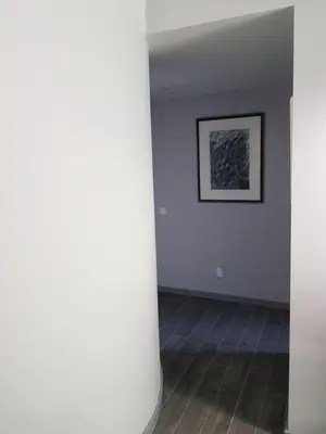 an empty room with white walls and wooden floors at By the Beach in Almancil