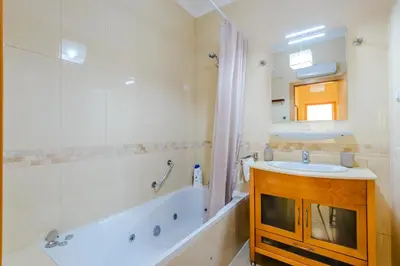 a bathroom with a tub and a sink and a mirror at BnB Homes Ocean view Apartment with Lovely Terrace, 2 Swimming pools & Tennis court in Albufeira