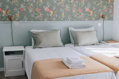 two beds sitting next to each other in a room at Dear Faro - Guest House in Faro