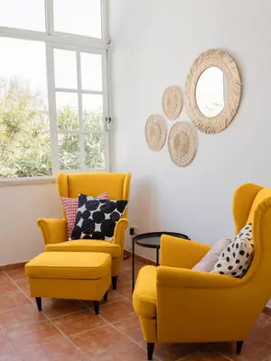 a living room with two yellow chairs and a table at Dear Faro - Guest House in Faro