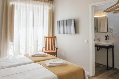 a bedroom with a bed and a sink and a mirror at Dear Faro - Guest House in Faro