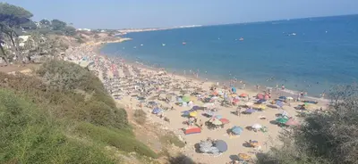 a crowd of people on a beach with umbrellas at Balaia Gardens, jardins da Balaia in Albufeira