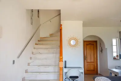 a staircase in a home with white walls and a wooden door at Casa Galé - Joia das Sesmarias 600mts praia in Albufeira
