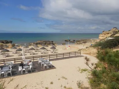 a beach with chairs and umbrellas and the ocean at Casa Galé - Joia das Sesmarias 600mts praia in Albufeira