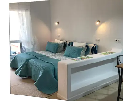 a bedroom with a bed with blue sheets and pillows at Albufeira Jardim 2 Studio in Albufeira