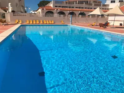 a large blue swimming pool in a building at Albufeira Jardim 2 Studio in Albufeira