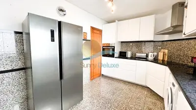 a kitchen with white cabinets and a refrigerator at Villa Golfinho by Sunny Deluxe in Albufeira