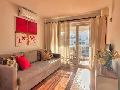 a living room with a couch and a window at Urbisol 202-Albufeira in Albufeira