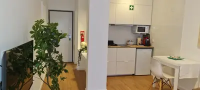 a kitchen with white cabinets and a table with a plant at Victoria Studio in Vilamoura