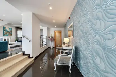 a hallway with a wall with a blue wave mural at Sunfield Guest House - Only Adults in Albufeira