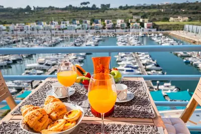 a table with a tray of food and two glasses of orange juice at Funtastic Albufeira Marina 1b3b in Albufeira