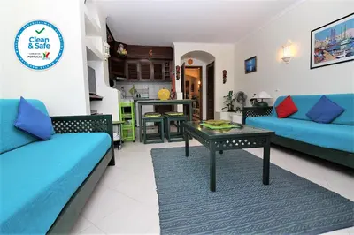 a living room with blue couches and a table at Belavista Centre - Albufeira in Albufeira