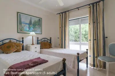 two beds in a bedroom with a window at Akisol Vilamoura Pine in Quarteira