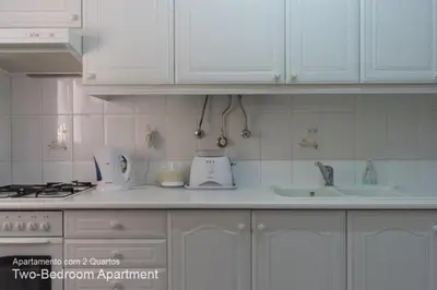 a kitchen counter with white cabinets and a sink at Akisol Vilamoura Pine in Quarteira