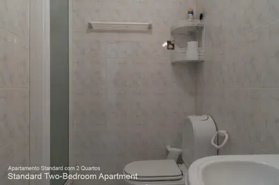 a bathroom with a white toilet and a sink at Akisol Vilamoura Pine in Quarteira