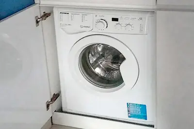 a white washing machine in a white cabinet at Charming Blue Albufeira in Albufeira