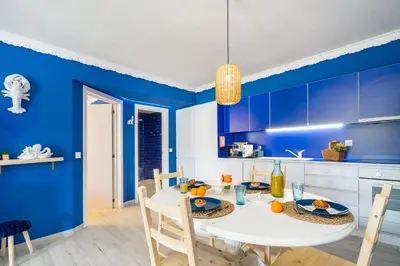 a blue kitchen with a white table and chairs at Charming Blue Albufeira in Albufeira