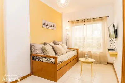 a living room with a couch and a window at Akisol Albufeira Falesia IV in Albufeira
