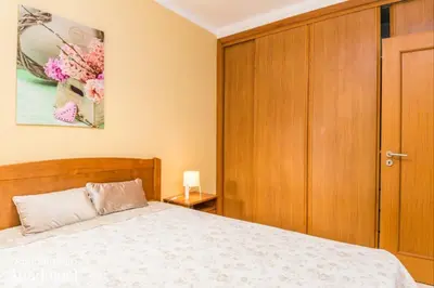 a bedroom with a bed and a wooden cabinet at Akisol Albufeira Falesia IV in Albufeira