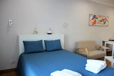 a bedroom with a blue bed and a chair at Vilamoura Dolphin Studio in Vilamoura