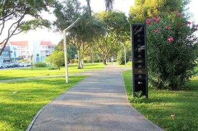 a sign in the grass next to a sidewalk at Vilamoura Dolphin Studio in Vilamoura