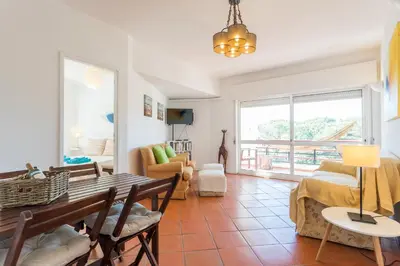 a living room with a table and chairs at FLH Vilamoura Central Flat in Quarteira