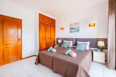 a bedroom with a bed with blue pillows at Villa Maldives by Algarve Vacation in Montes Borralhos