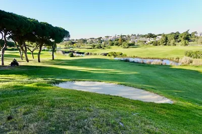 a golf course with a puddle of water on a green at Villa Formosa Golf in Quinta do Lago