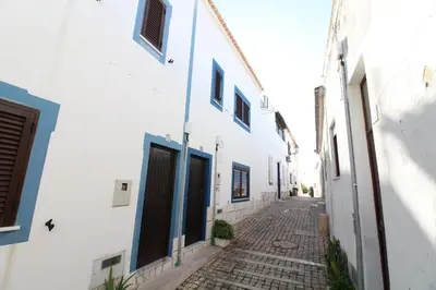 an alley with white walls and a cobblestone street at Fisherman's Townhouse at Old Town in Albufeira
