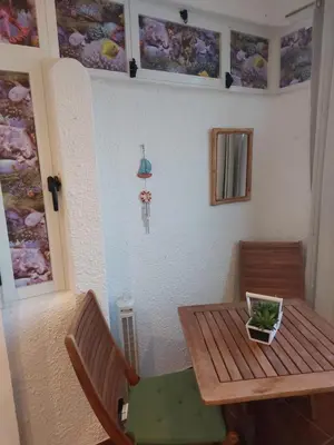 a room with a table and chairs and an umbrella at Apartamento Quarteira T1 in Quarteira